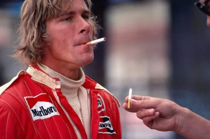 James Hunt si accende una sigaretta. Gesto normale all'epoca in F1 