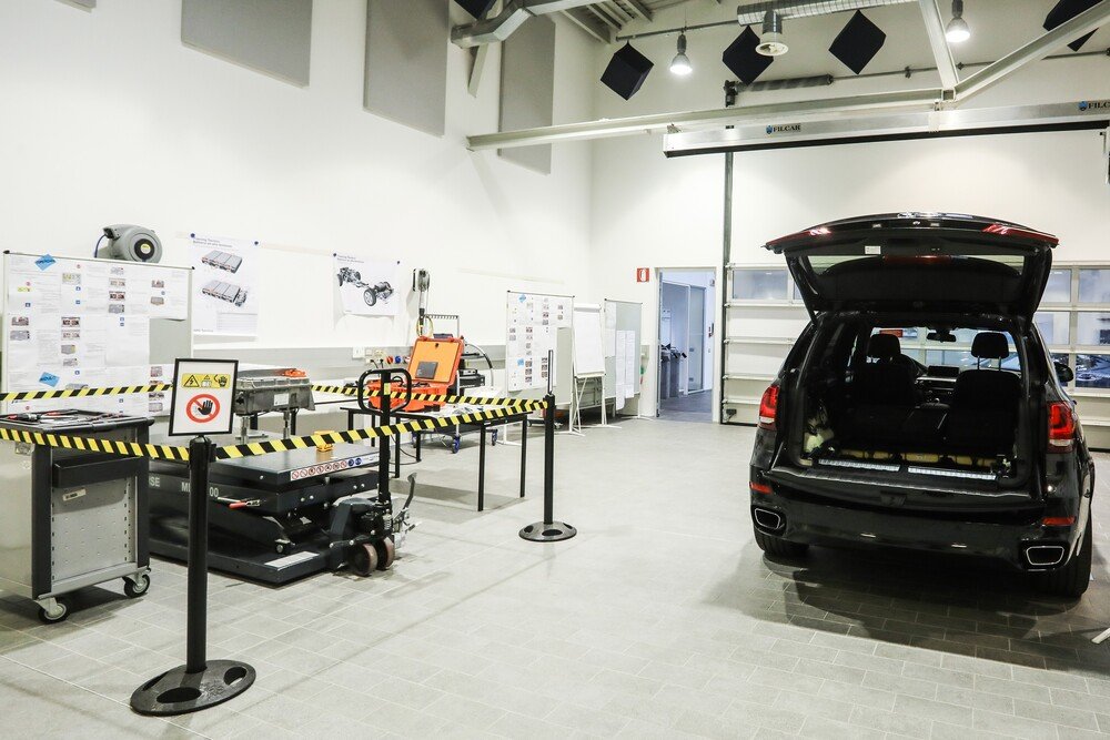 BMW X5 ibrida con batteria estratta, dal fondo vano bagagli e riposta in area lavoro