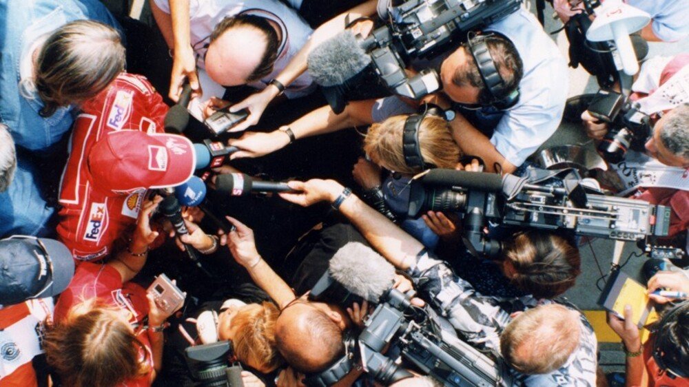 1999: Schumi attorniato dai cronisti. La pressione dei media &egrave; stata una costante della sua carriera, ma secondo Buchinger non lo ha mai messo in crisi