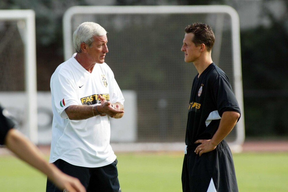 Non solo Formula 1: Schumacher parla con Marcello Lippi in occasione di un allenamento con la Juventus. E&#039; stato per anni attaccante della Nazionale Piloti di calcio