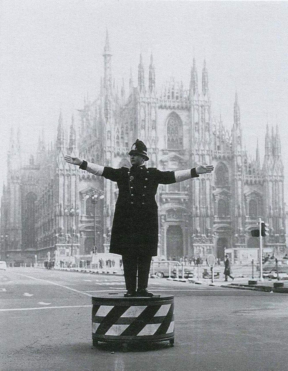 Simbolica immagine di Milano: ghisa su pedana dirige traffico in piazza Duomo