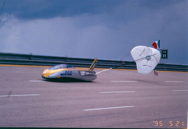 La Zer sulla pista di Nard&ograve;, nelle Puglie, mentre aziona il freno aerodinamico a paracadute, il 21 maggio &rsquo;95, subito dopo la conquista del record del mondo di velocit&agrave; per veicoli elettrici, a 303,977 km/h. Era guidata da Oscar De Vita, allora studente di ingegneria del Politecnico di Milano, che aveva partecipato al progetto, diventato poi la sua tesi di laurea