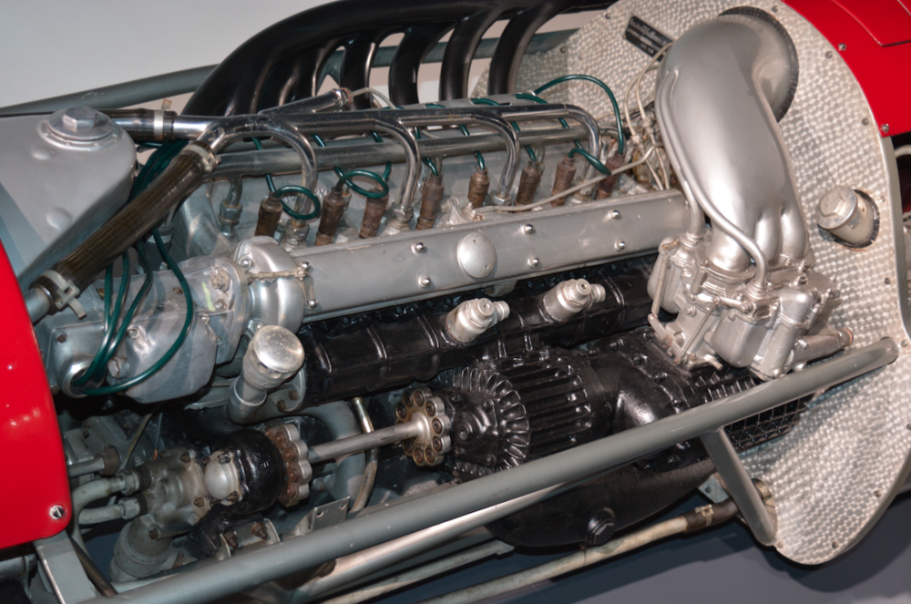 3-	Le ultime Alfa Romeo da GP a 8 cilindri in linea erano sovralimentate mediante due compressori Roots, ben visibili in questa immagine, per il cui azionamento erano necessari ben 135 cavalli. Il motore aveva una cilindrata di 1500 cm3 e una potenza dell&rsquo;ordine di 420 CV a 9300 giri/min