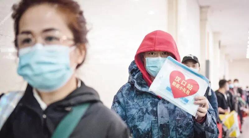 Passeggeri cinesi in attesa dell'imbarco a Wuhan