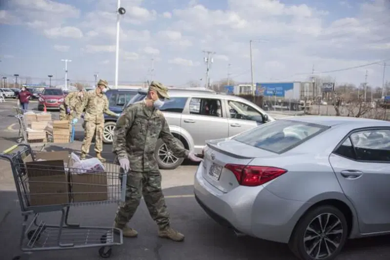 Indiana (US) militari mettono provviste di cibo in auto per i bisognosi, che possiedono ancora un'auto ma non pi&ugrave; il lavoro