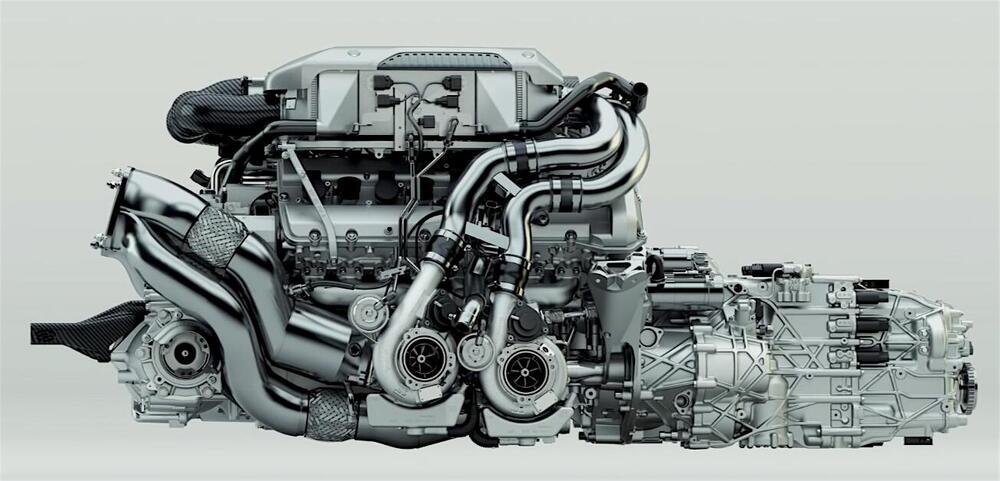 Il motore Bugatti a 16 cilindri &egrave; sovralimentato per mezzo di quattro turbocompressori (due dei quali ben visibili in questa foto). Il sistema di alimentazione dispone di due intercooler aria/acqua. I due alberi a camme collocati in ciascuna testa azionano le valvole (64 in totale!) tramite bilancieri a dito