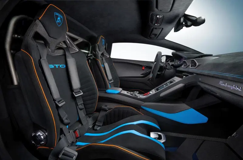 Sedili racing con cinture a quattro punti e roll bar in titanio firmato Akrapovic per l'abitacolo della Huracan STO