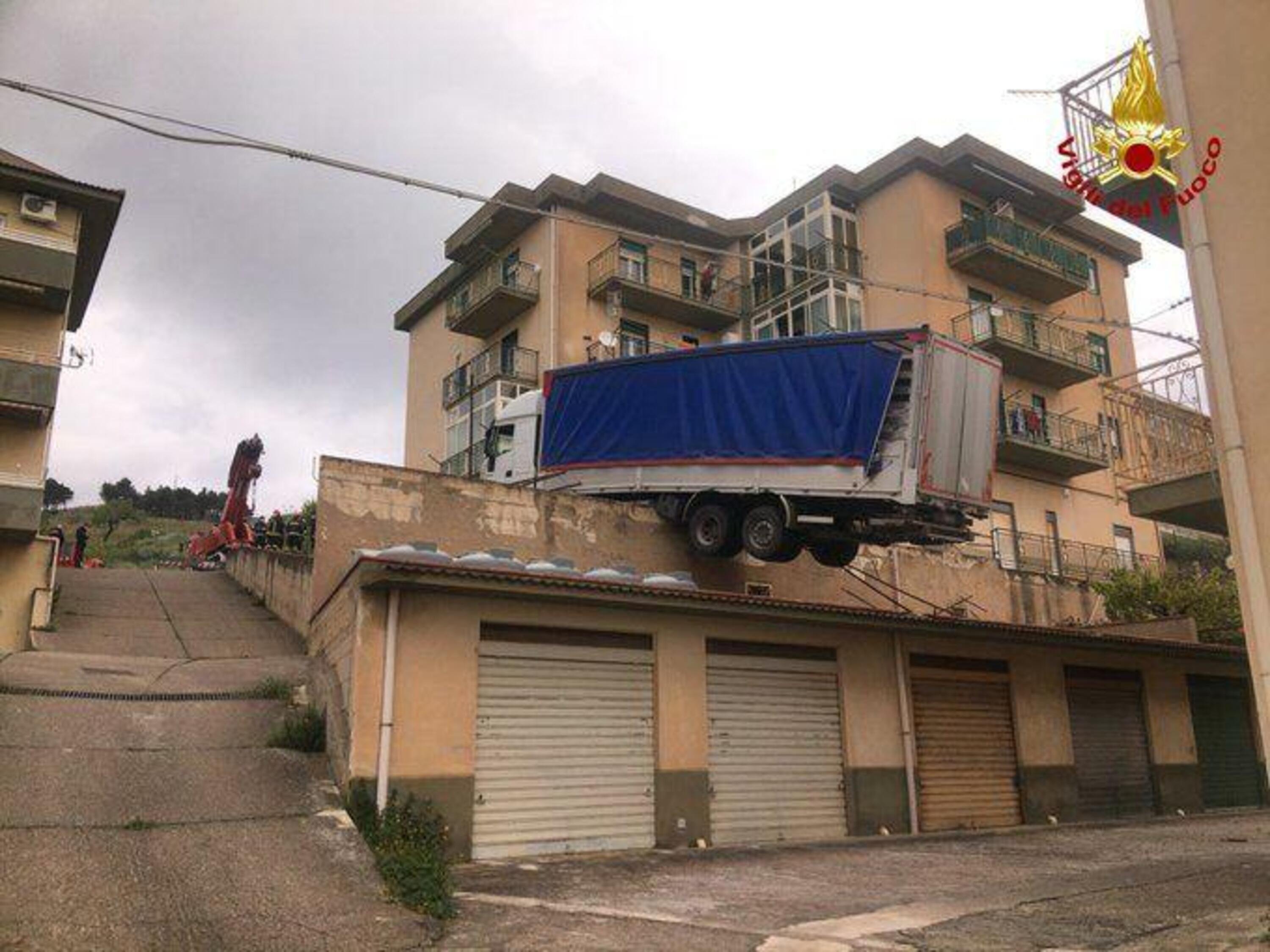Pazzesco in Sicilia: un Tir in bilico sui tetti a Caccamo [foto Vigili del Fuoco]