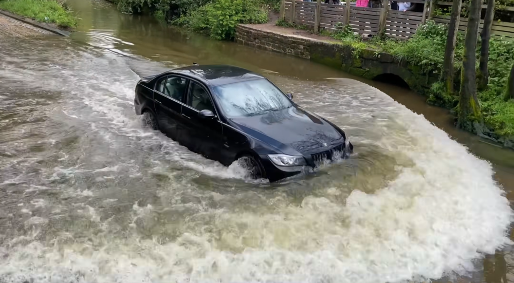 Una BMW Serie 3 mentre attraversa una strada allagata nel Regno Unito