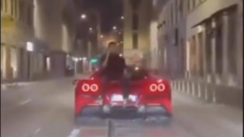 Milano &egrave; follia: seduto sul cofano di una Ferrari al telefono 