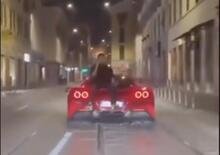 Milano è follia: seduto sul cofano di una Ferrari al telefono 