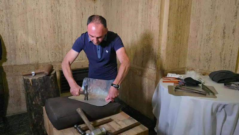 Daniele Ravera al lavoro mentre sagoma l'alluminio