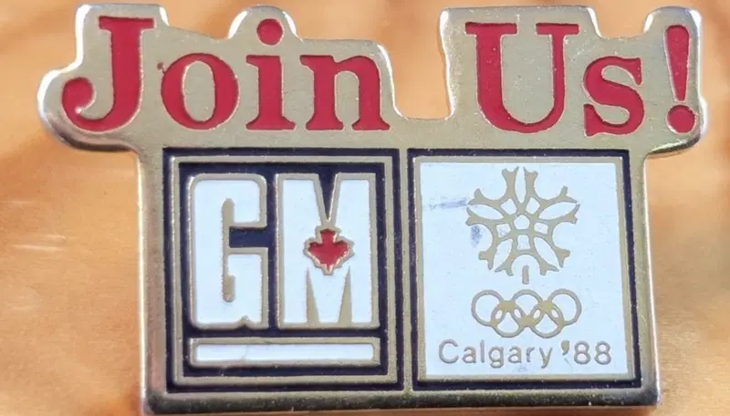 Spilla slogan "Join Us!" di&nbsp;General Motors&nbsp;per le Olimpiadi Invernali di&nbsp;Calgary 1988