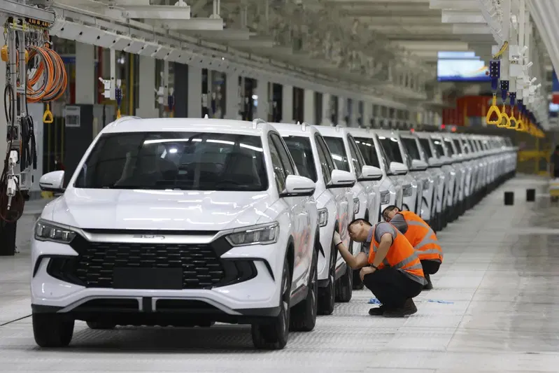 Operai puliscono le vetture per l'inaugurazione dello stabilimento BYD di Camacari, in Brasile