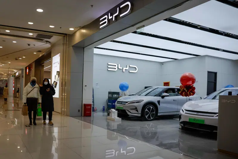 Due donne passano accanto a uno showroom BYD all&rsquo;interno di un centro commerciale di Beijing, in Cina, il 19 gennaio 2024. Xin Guobin, viceministro del Ministero dell&rsquo;Industria e dell&rsquo;Information Technology cinese, ha dichiarato durante una conferenza stampa che la Cina ha esportato 4,91 milioni di veicoli nel 2023, con un aumento del 57,9% su base annua, diventando cos&igrave; il pi&ugrave; grande esportatore automobilistico al mondo.