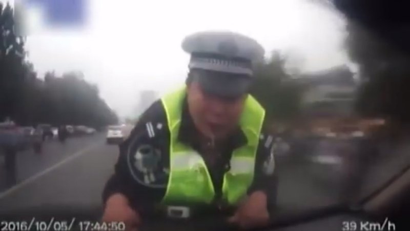 Vigile zelante si aggrappa alla macchina per non far sfuggire il conducente [Video]